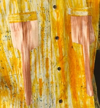 Poches allongées saumon sur une chemise batik ocre